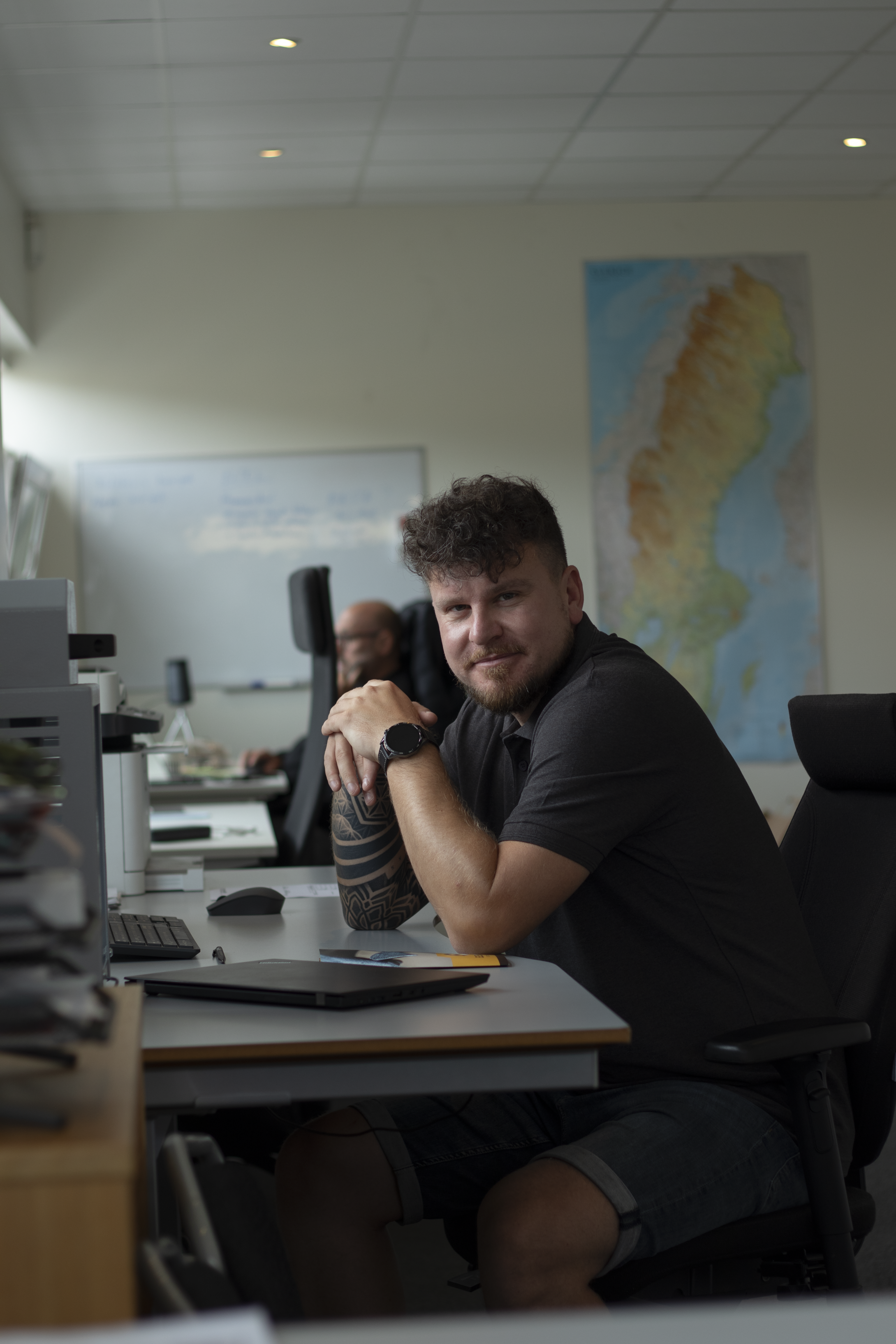 Inköpare på Elemet Recycling AB sitter vid sitt skrivbord på företagets kontor i en professionell kontorsmiljö.